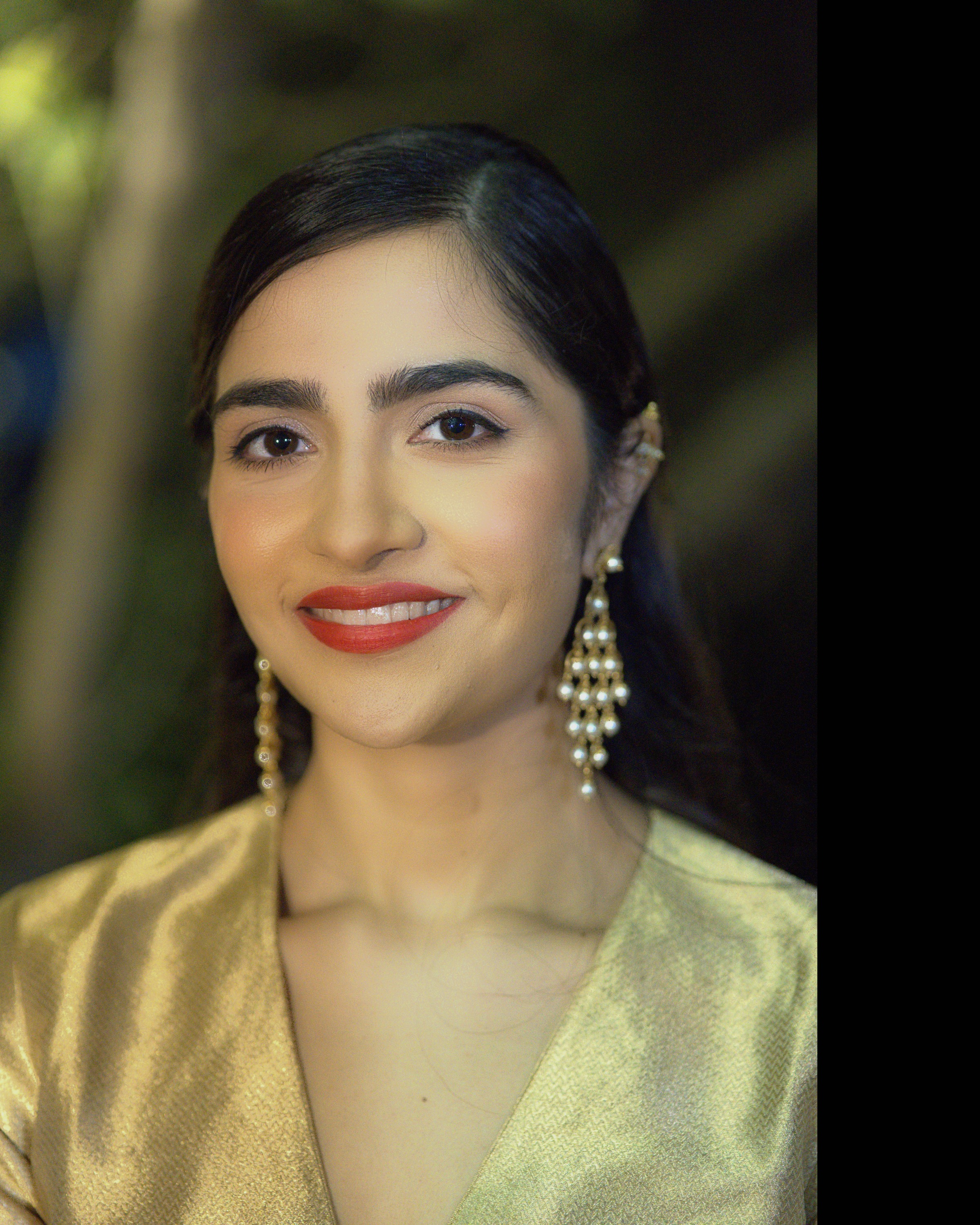 Rukmini Vasanth smiling portrait in gold