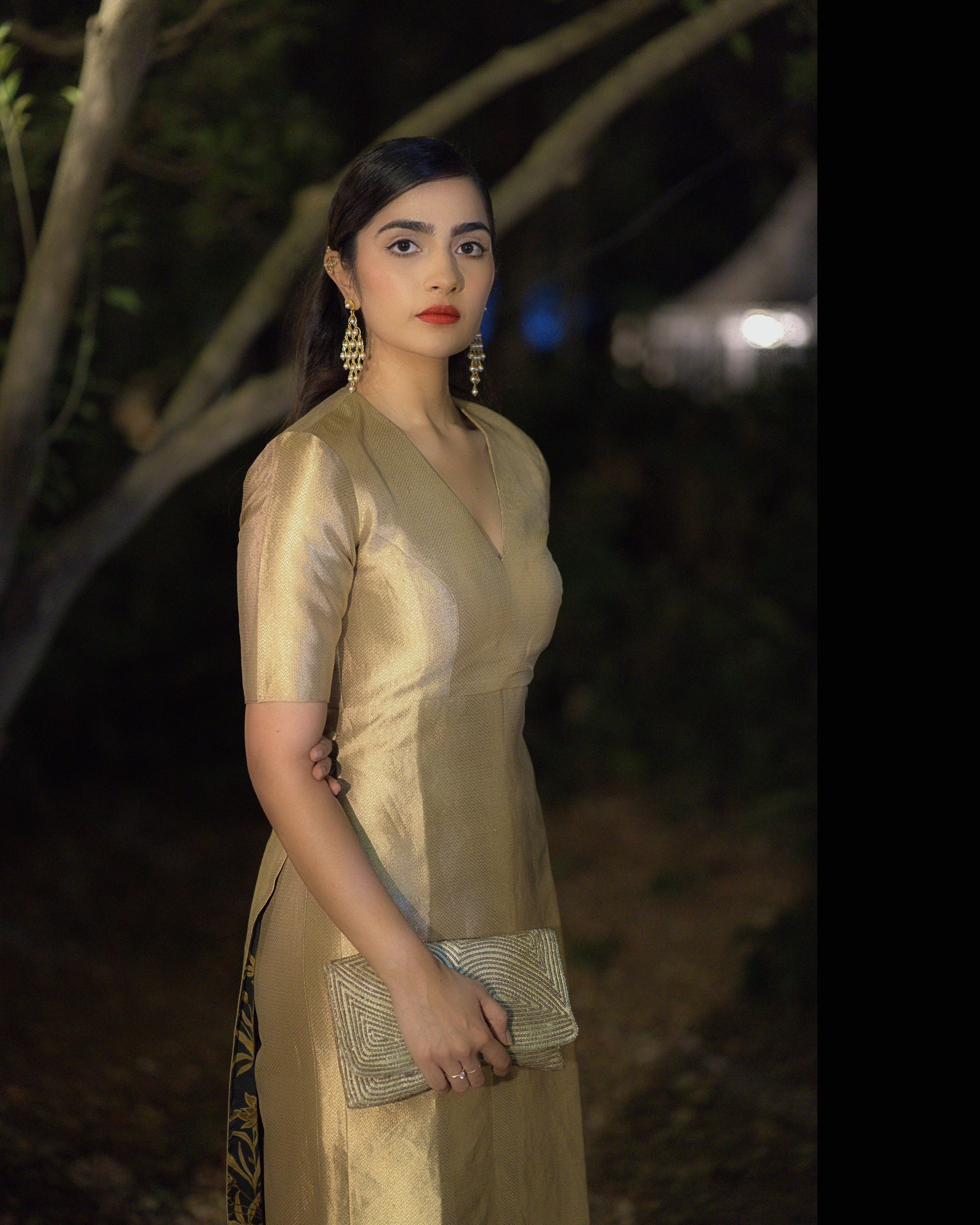 Rukmini Vasanth with a gold clutch, night garden