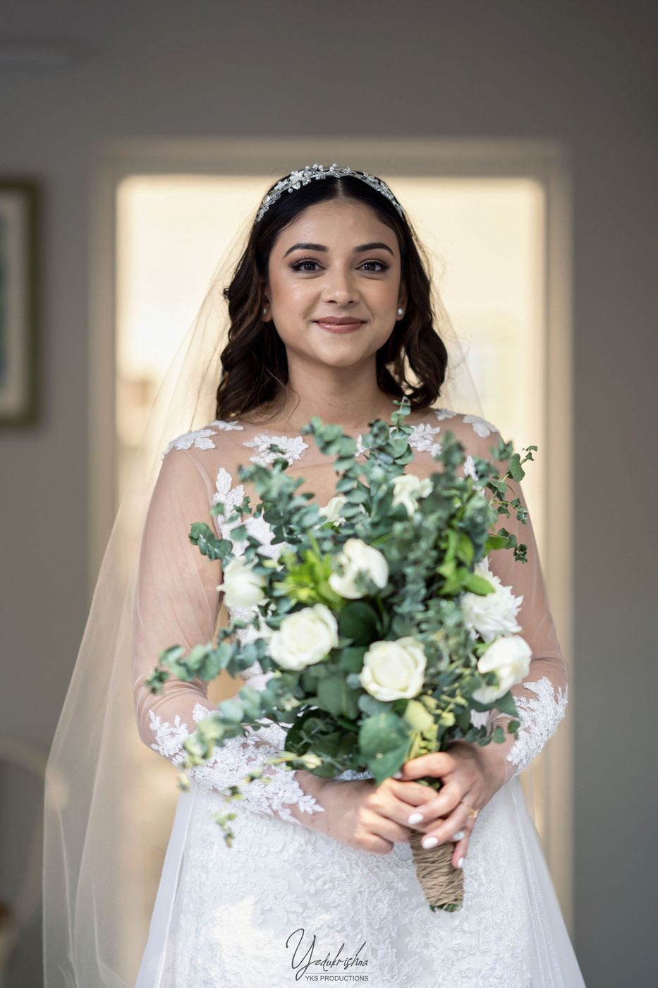 Bride with the bouquet in window light