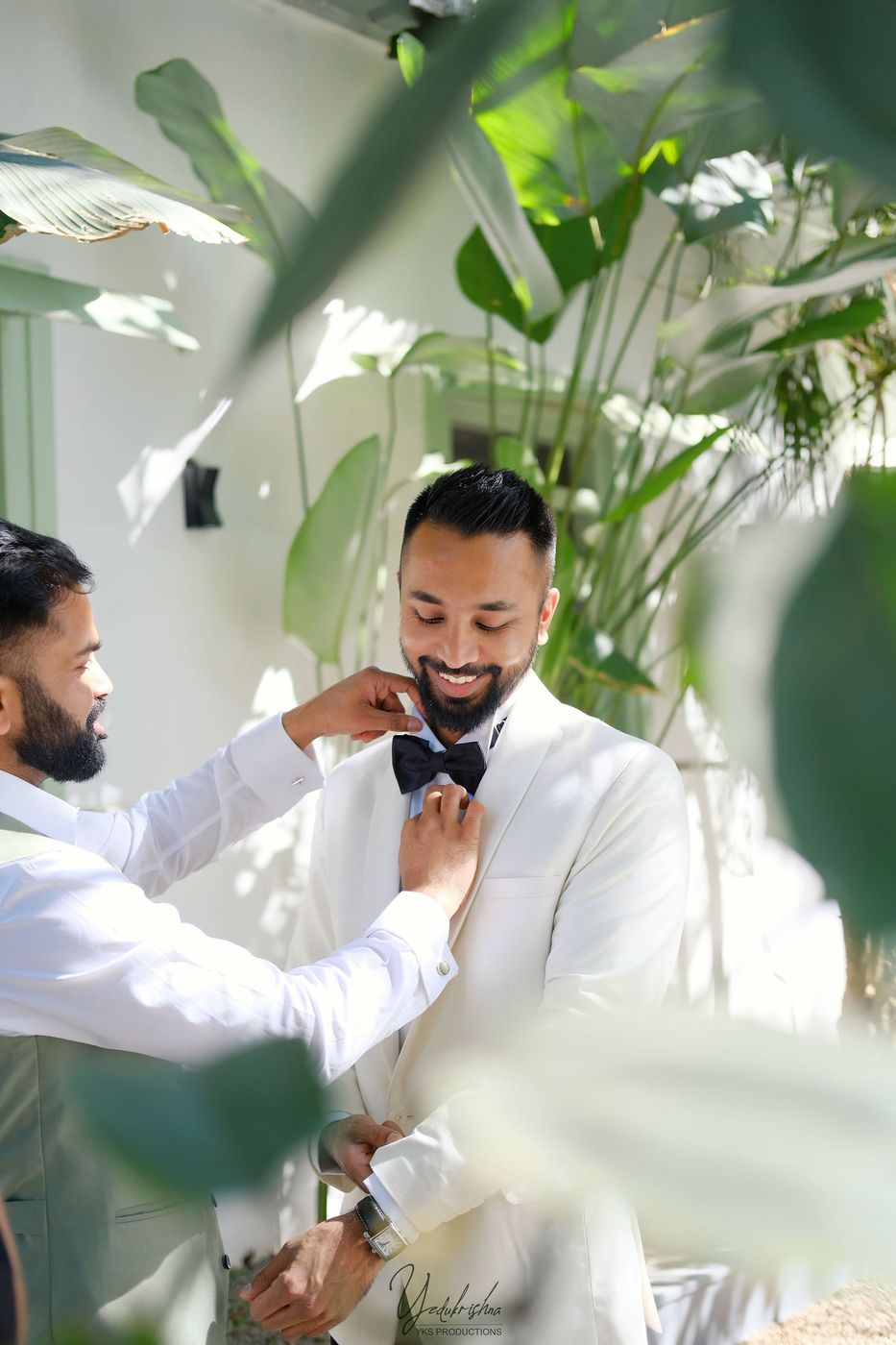 Groomsmen fixing the bow tie